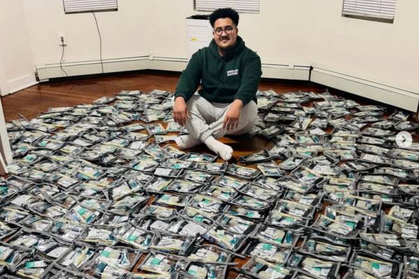 Hamza Faik surround by Hygiene Kits for Rosie’s Place