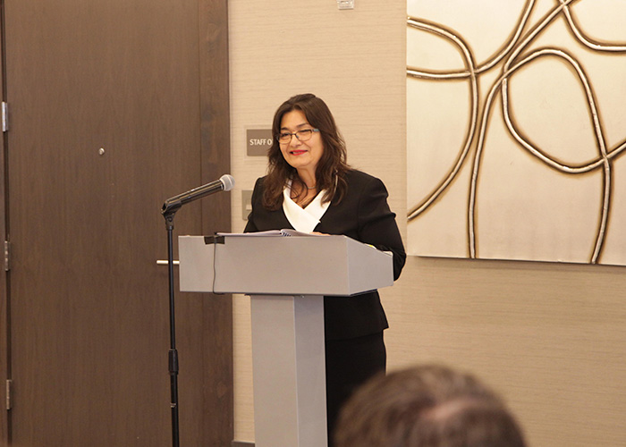 Alice Murillo speaking at a podium