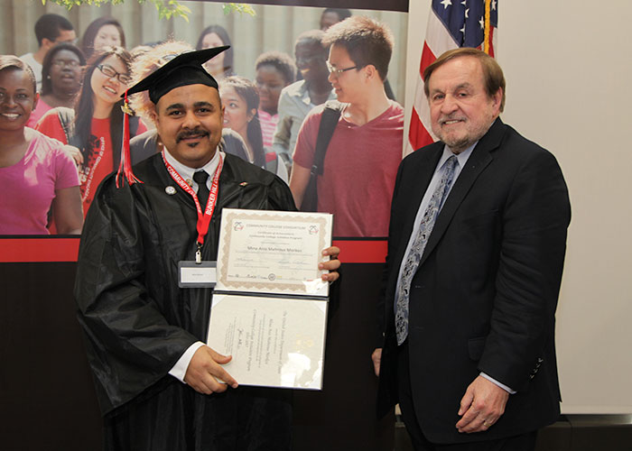 male student posing with certificate and dr. canniff