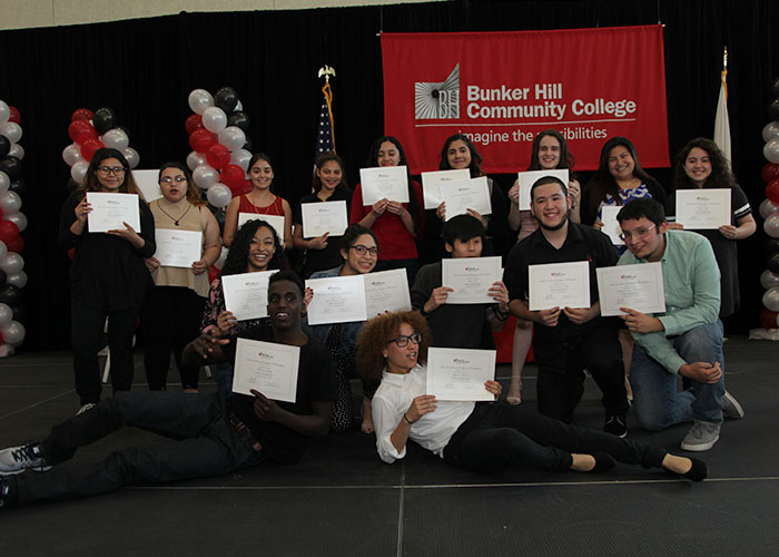larger group of students posing with their certificates