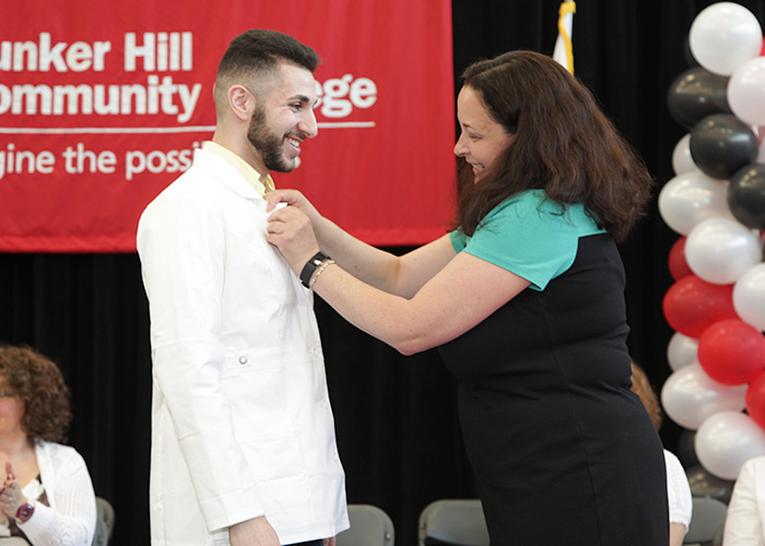 male student receiving his pin from faculty member