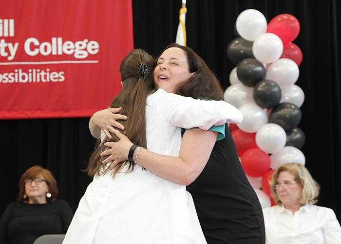 female student and faculty member hugging