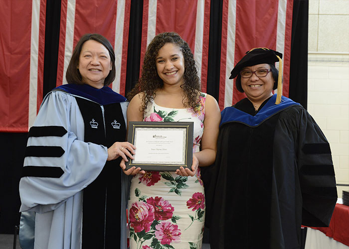 female awardee with president and dean puente