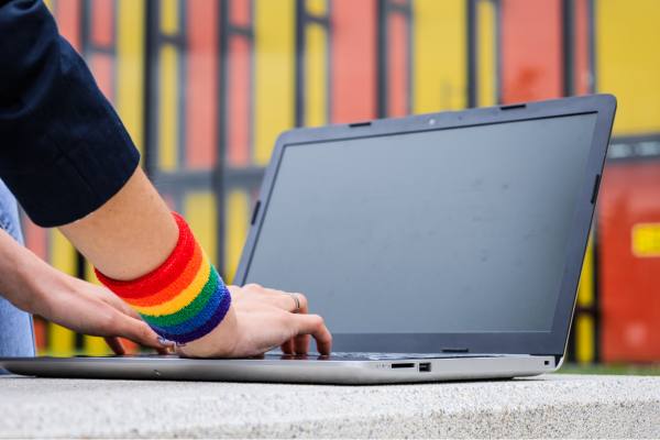 hands typing with a rainbow band