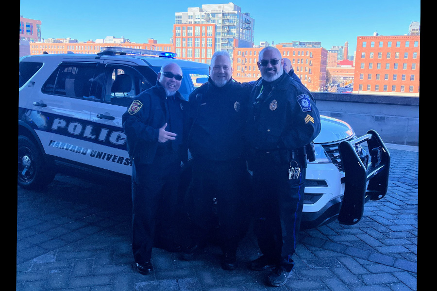 Three officers in front of a cruiser