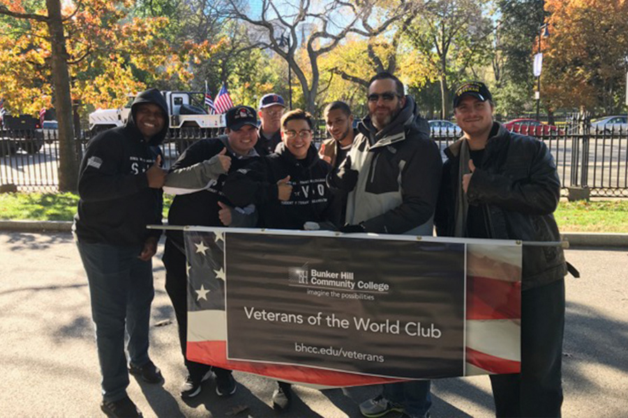 BHCC Veterans and staff posing with their veterans day parade banner