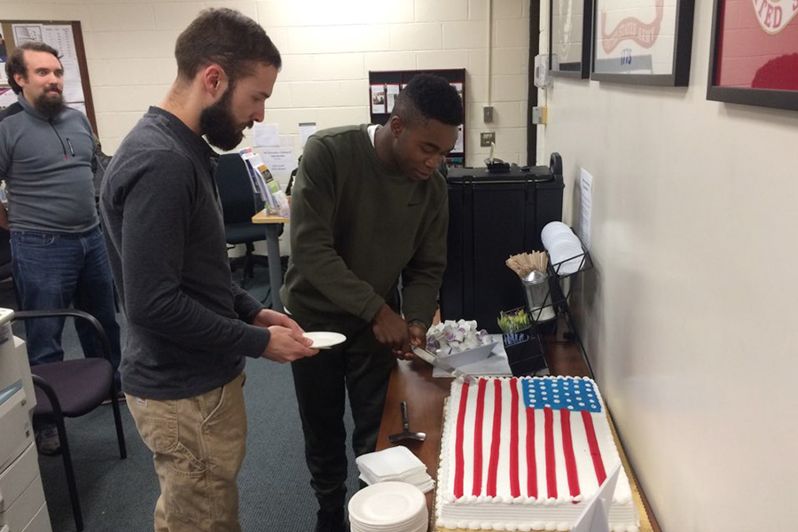 Two Veterans cutting an american flag cake