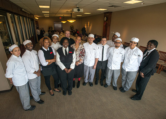 Terry McMillan in the culinary arts dining room with students
