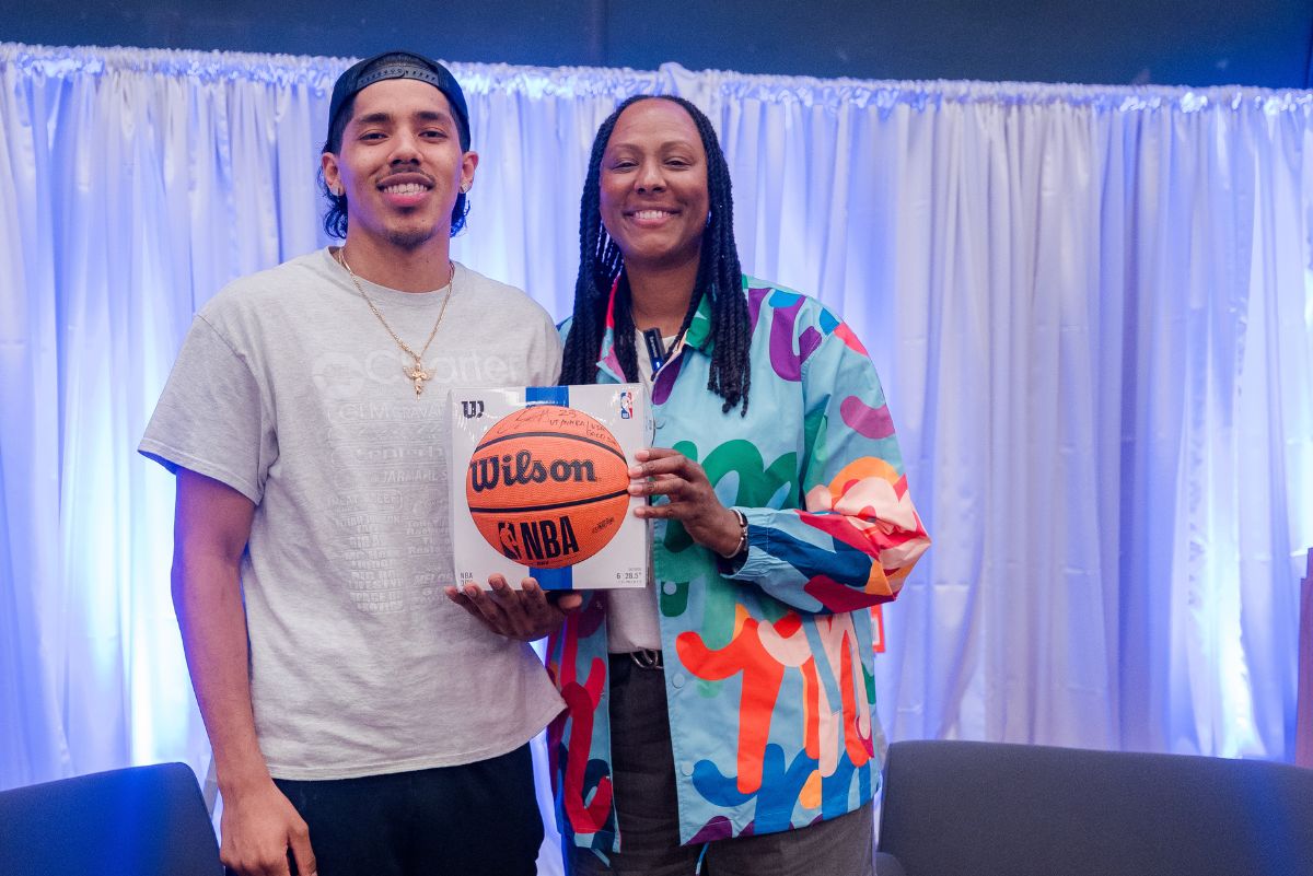 Chamique Holdsclaw holding basketball with student