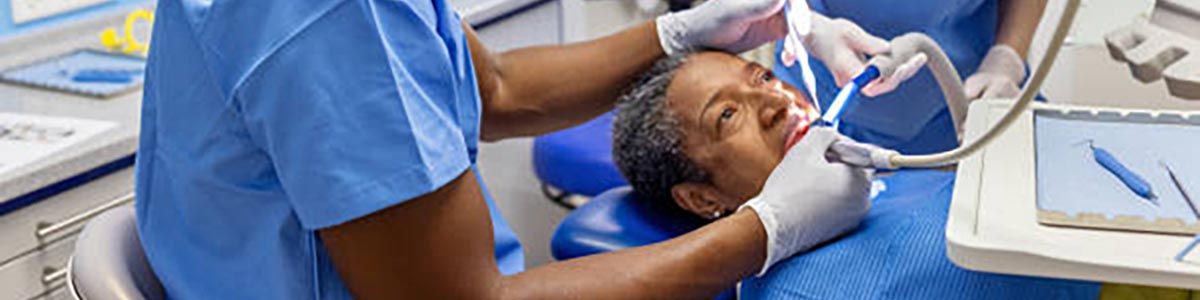 A dentist and his assistant working on a patient A dentist and his assistant working on a patient