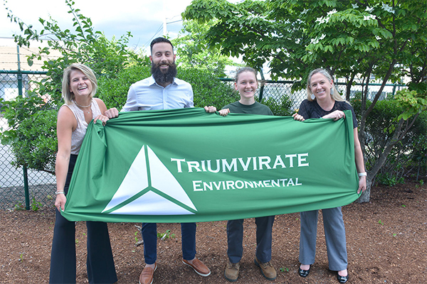 Triumvirate employees holding a flag